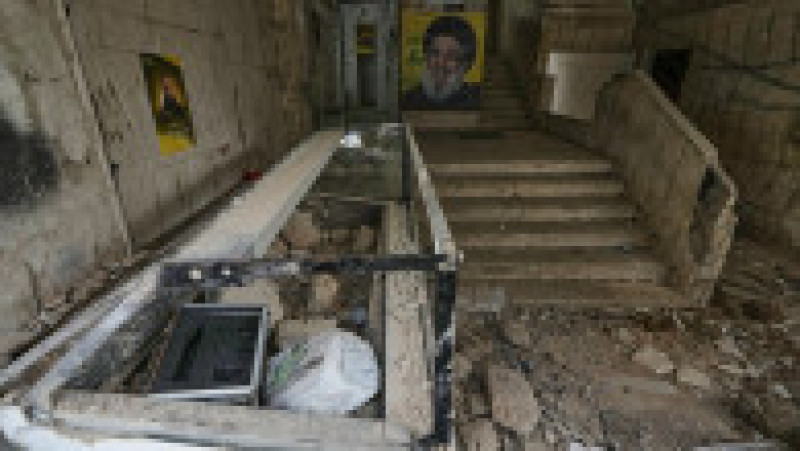Un portret al defunctului lider al Hezbollah, Sayyed Hassan Nasrallah (&icirc;n centru), at&acirc;rnă la intrarea &icirc;ntr-o clădire avariată &icirc;n urma unui atac aerian israelian &icirc;n Dahiyeh, suburbiile sudice ale Beirutului, Liban, s&acirc;mbătă, 4 aprilie 2026. Foto: Bilal Hussein / AP / Profimedia | Poza 7 din 9