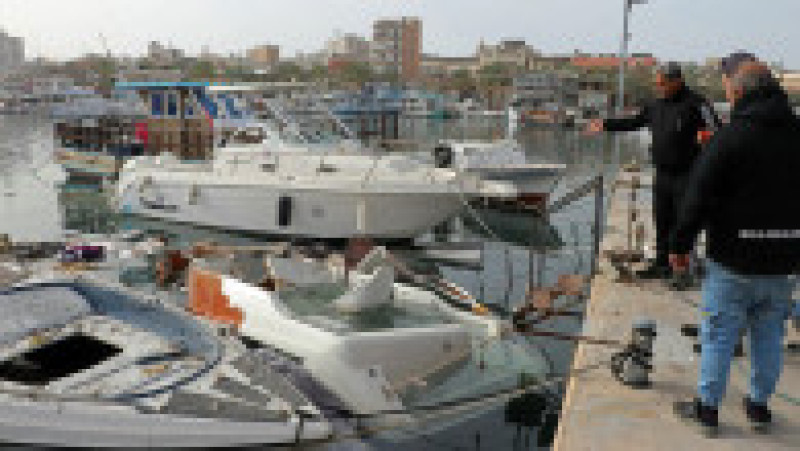 Bărbați inspectează ambarcațiunile avariate la locul unui atac israelian &icirc;n portul orașului libanez de coastă Tir, pe 4 aprilie 2026 Foto: Kawnat HAJU / AFP / Profimedia | Poza 6 din 9
